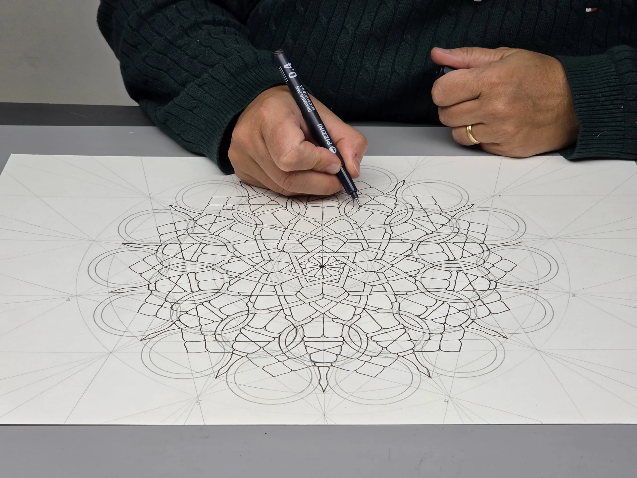 Mano dibujando un mandala geométrico a lápiz: no hace falta saber dibujar para empezar