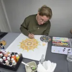 Mujer pintando mandalas en acuarela en un taller de arte curativo