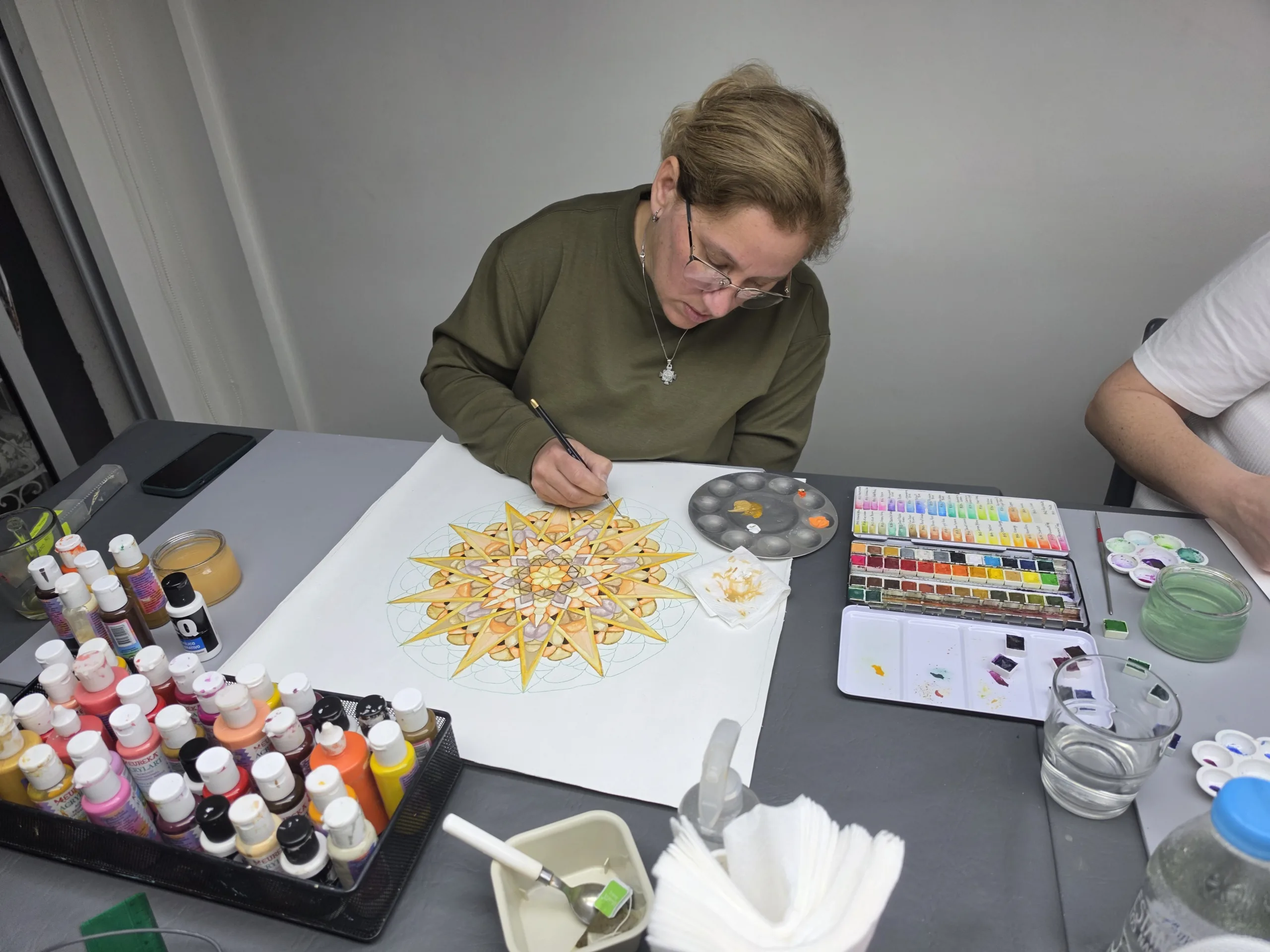 Mujer pintando mandalas en acuarela en un taller de arte curativo
